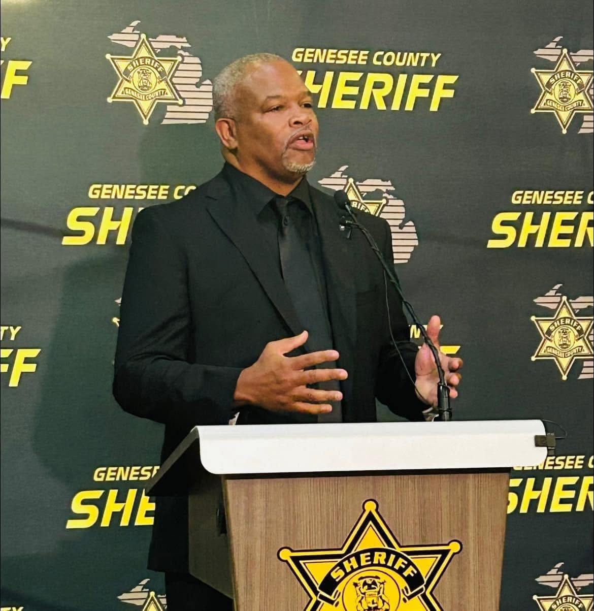Darryl Woods Sr. speaking at the Genesee County Sheriff podium
